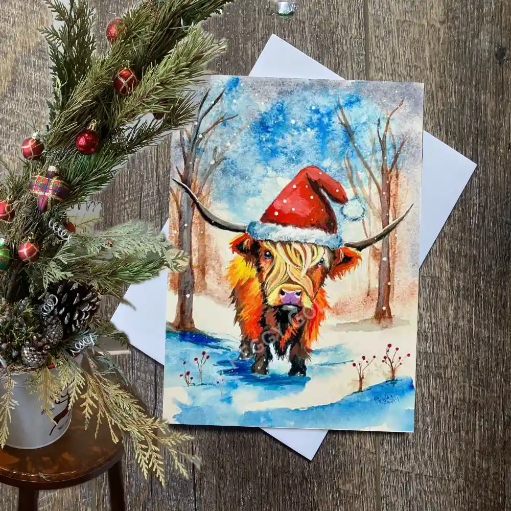 Highland cow Christmas card with a Santa hat in a forest scene